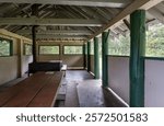 View inside a picnic shelter with a large stove and evergreen trees in background
