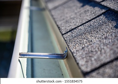 view inside roof gutter with clips and edge of shingles 