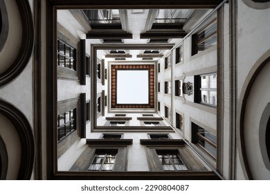 A view inside a square patio inside a block in Florence Italy, looking up