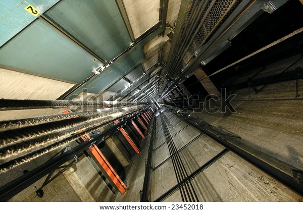 The view up inside\
a tall elevator shaft.