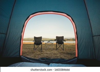 View from inside tent, Outdoor two empty chairs with picnic table and moka pot coffee for Camping.