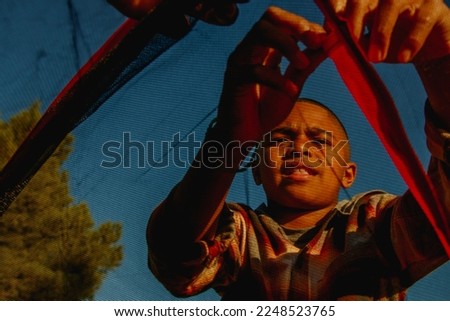 View from inside tent of son helping to put together camping tent