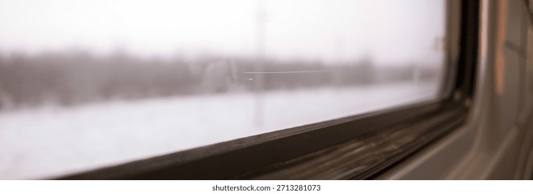 A view from inside a train car at sunset through the glass on a cold winter evening in a cozy train on a long journey