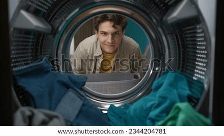 View from inside the washing machine, adult man looking at the camera and smiling