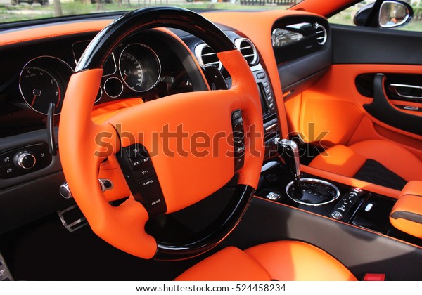 View of the interior of a modern\
automobile showing the dashboard. Tuning. Orange luxury car.\
Supercar. Orange. England. Tuning. Karbon. Europe.\
Car