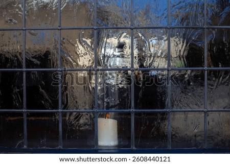 View into old leadlight windows with lit candle  for use as a background texture