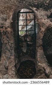 View from an iron window attached to a cave carved into an ancient rock.