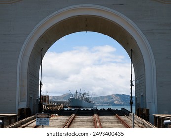 A view of the Jeremiah O'Brian liberty ship and the Marin Headlands. The archway and the rails in the foreground serve as a launch for boats into San Francisco harbor. - Powered by Shutterstock