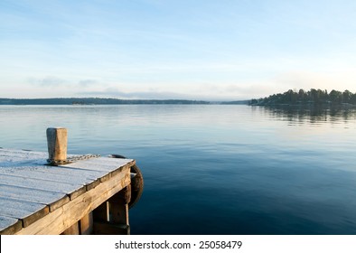 View from the jetty over a calm lake in the evening. - Powered by Shutterstock