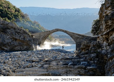 View of the Kadiut Bridge in Benje, Permet, Albania. Ancient stone bridge. Beautiful natural wonders. Holidays and leisure time. Fisherman fishing in the river. Natural thermal baths. - Powered by Shutterstock