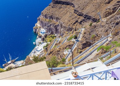 View of Karavolades Stairs-Long, twisting staircase leading from a hilltop village down a steep hill to a harbor at the Caldera coast,Aegean Sea,Greece - Powered by Shutterstock