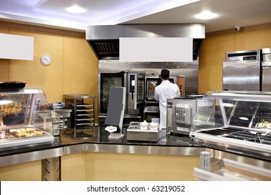 View Of A Kitchen With Baker Preparing Breads And Baguettes In A Cafeteria