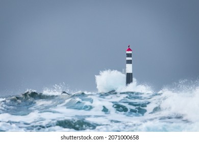 A view of Kraka Lighthouse and big waves in the Atlantic Ocean, Norway