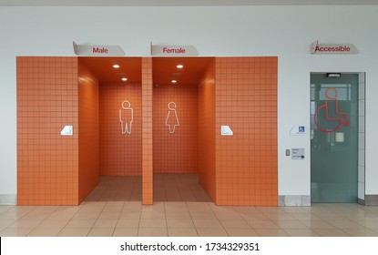 View of the lady, gentlemen and accessible's public toilet or bathroom entrance with bright orange tiles. - Powered by Shutterstock