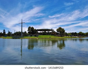 View Of Lake, Chaple And Big Christian Cross In Simón Bolívar Metropolitan Park, Greenspace And Entertainment And Sports Complex And Popular Public Park In The Middle Of Bogota, Colombia. 