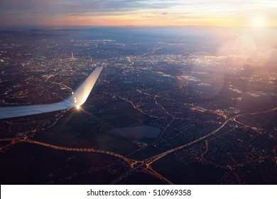 View from a landing airplane out the window of city at sunset - Powered by Shutterstock