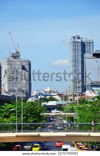 View landscape cityscape with asian labor people\
and thai labour workers use heavy machinery working builder new\
build concrete structure at construction site on June 18, 2022 in\
Bangkok, Thailand