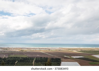 view of landscape with the sea, fields and clouds 