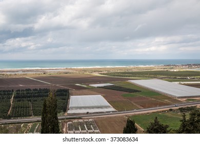 view of landscape with the sea, fields and clouds 