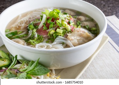 A View Of A Large Bowl Of Pho With A Variety Of Meat Inside, In A Restaurant Or Kitchen Setting.