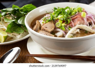 A View Of A Large Bowl Of Pho With A Variety Of Meat Inside, In A Restaurant Or Kitchen Setting.