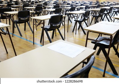 View of large exam room hall and examination desks tables lined up in rows ready for students at a high school to come and sit their exams tests papers. 