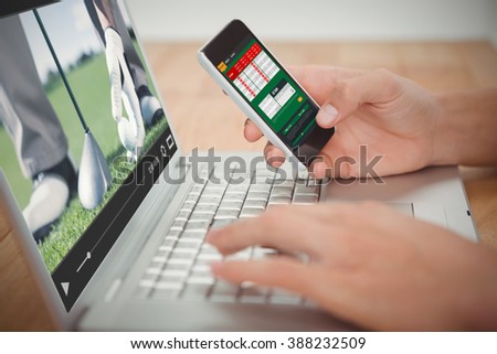 View of lecture app against man holding mobile phone while typing on laptop at desk