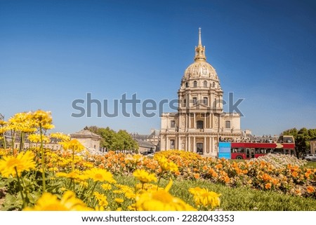 View of Les Invalides with spring flowers and tour bus in Paris, France