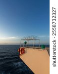 View of the lifebuoy, compass and the lookout post covered with razor wire to deter sea birds on the bridge wings in a ship at sea