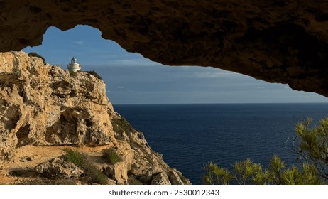 View to the lighthouse from inside the cave at the coast.