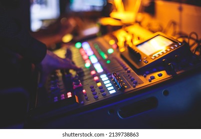 View of lighting technician operator working on mixing console workplace during live event concert on stage show broadcast, light mixer controller panel, sound technician with professional equipment
				