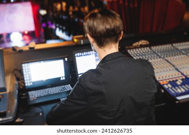View of lighting technician operator working on mixing console workplace during live event concert on stage show broadcast, light mixer controller panel, sound technician with professional equipment