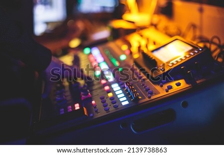 View of lighting technician operator working on mixing console workplace during live event concert on stage show broadcast, light mixer controller panel, sound technician with professional equipment
