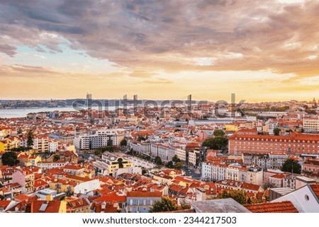 View of Lisbon famous view from Miradouro da Senhora do Monte tourist viewpoint of Alfama and Mauraria old city district, 25th of April Bridge at sunset. Lisbon, Portugal