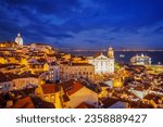 View of Lisbon famous view from Miradouro de Santa Luzia tourist viewpoint over Alfama old city district at night with cruise liner. Lisbon, Portugal.