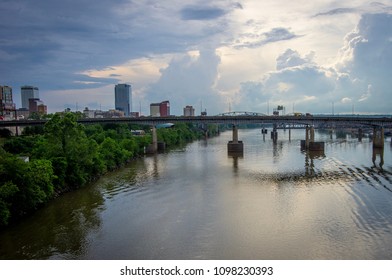 View Of Little Rock Bridges Crossing The Arkansas River With The Downtown Skyline Behind Them.