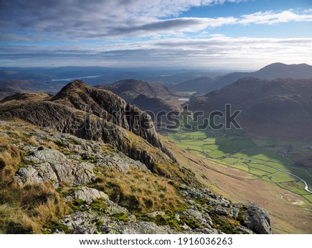View to Loft Crag from Pike of Stickle overlooking the Great Langdale valley with Blea Tarn nestled in the fells and Windermere lake in the background, Langdale Pikes, Lake District, UK