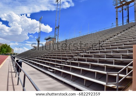 View looking across stadium bleachers with blue sky and clouds