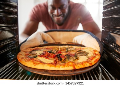 View Looking Out From Inside Oven As Man Cooks Fresh Pizza