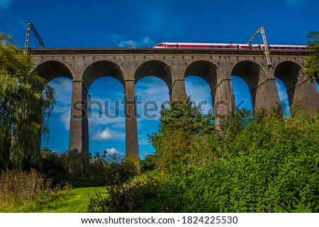 A view looking up at a train crossing the Digswell Viaduct near Welwyn Garden City, UK in the summertime