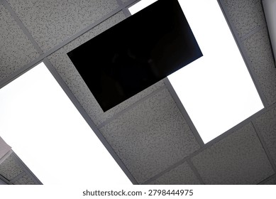 View looking upward toward a ceiling-mounted television and overhead lighting from a dental treatment chair in a modern dental office.