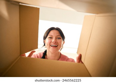 View Looking Up At Young Excited Woman Opening Cardboard Box - Powered by Shutterstock