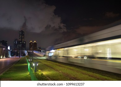 The View Of LRT (light Rail Transit) In Kaohsiung City, Taiwan. When It Passes At Night. You Can Also See 85 Sky Tower Far Away In This Photo.