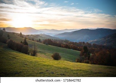 View of magnificent landscape with bright colorful sky over morning valley and mountains. Amazing sunrise in farm field with haystack on grassland over rolling hills. Concept of nature. - Powered by Shutterstock