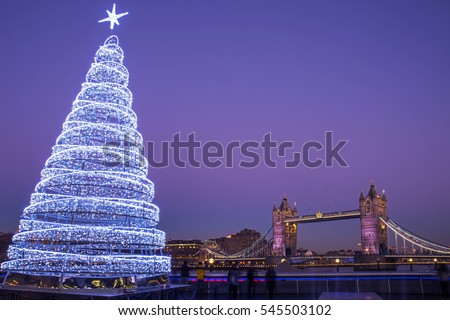 A view of the magnificent Tower Bridge with an illuminated Christmas Tree in London.