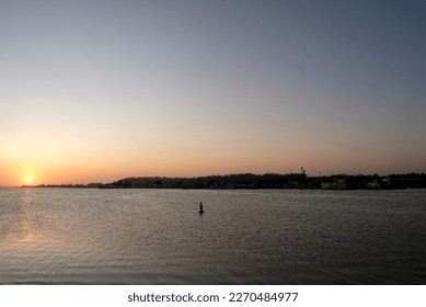 A view from the main beach bridge looking back to Lakes Entrance at sunset. There was a bushfire in the local hills that contributed to the hazy effect.