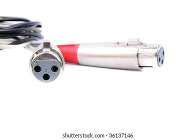 A view of the male and female pins of XLR cables used for connecting recording devices in a music studio, isolated on a white background