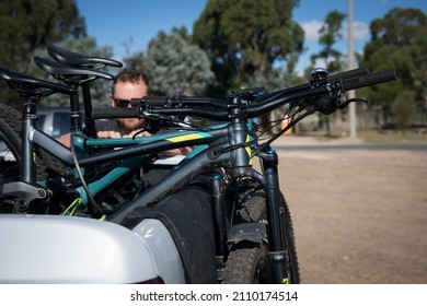 View of a man loading a bike into a ute
