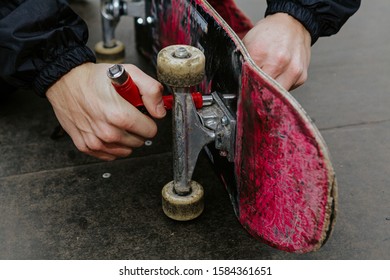 View Of A Man Repairing His Skateboard In The Skate Park. 