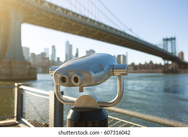 View of Manhattan bridge and New York City with a coin operated telescope binoculars viewer for tourists.